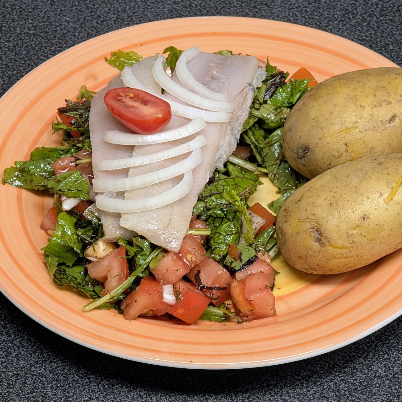 Salzheringsfilet auf einem Salatbett mit Pellkartoffeln