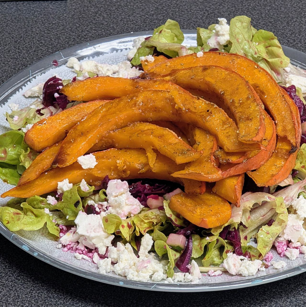Würzige Kürbisspalten auf einem Rotkraut-Rote Beete-Salat